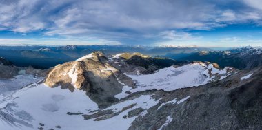 Kanada, BC 'de dramatik bir gökyüzü altında karla kaplı dağlar..