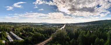 Burnaby, BC, Kanada 'nın hava görüntüsü, canlı yeşillik ve kentsel ufuk çizgisi.