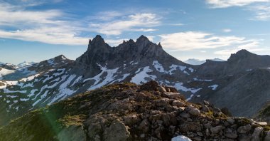 BC, Kanada 'da canlı gökyüzü altında kar yamaçları olan dramatik kayalık dağ sırası