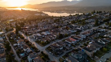 Burnaby, BC, Kanada 'nın huzurlu altın günbatımında geniş kentsel manzarası.
