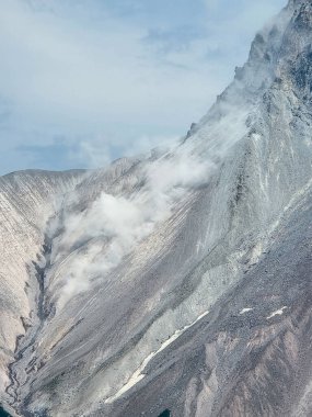 Squamish, BC 'de bulutlu ve sisli engebeli bir dağın dramatik manzarası..