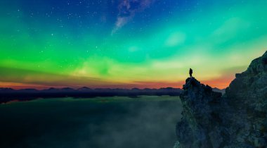 Dağlık arazide canlı bir Aurora 'ya karşı silueti olan bir insanın 3 boyutlu görüntüsü.