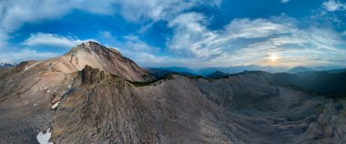 Kanada, BC 'de kayalık sıradağların ve renkli günbatımı gökyüzünün nefes kesici panoramik manzarası