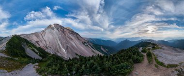 MÖ 'deki yemyeşil yemyeşil ve açık mavi gökyüzü ile dağların panoramik manzarası.