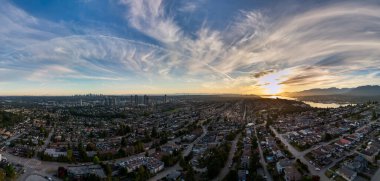 Burnaby, BC 'nin panoramik hava görüntüsü, günbatımı renkleri ve uzak şehir silueti.