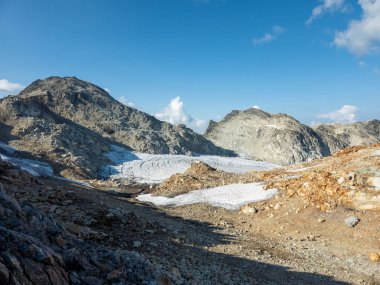 Squamish, BC, Kanada 'da canlı gökyüzü altında buzulların yer aldığı manzaralı kayalık alp arazisi.