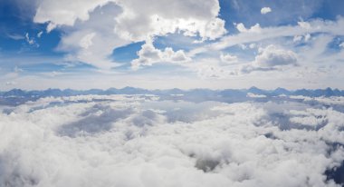 Bulutların ve dağların 3 boyutlu görüntüsü mavi gökyüzü altında.