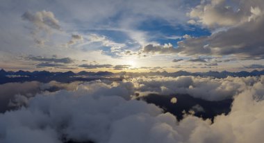 Bir dağ silsilesinin sakin bir gündoğumu görüntüsü ve 3 boyutlu görüntüleme kullanılarak oluşturulan bulutlar.