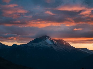 Gündoğumu, Squamish ve Whistler, BC, Kanada yakınlarındaki dağ zirvelerini ve bulutları aydınlatır..