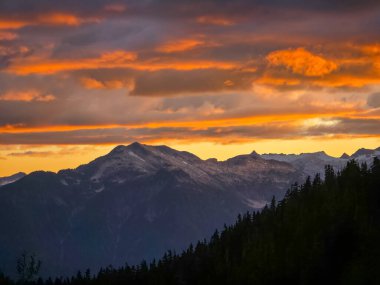 Squamish ve Whistler, BC, Kanada yakınlarındaki engebeli dağların üzerinde canlı gün batımı.