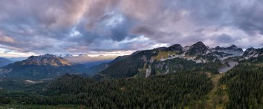 Engebeli dağların, sık ormanların ve Kanada 'nın Britanya Kolumbiyası' nda alacakaranlıkta dramatik bulutların nefes kesen manzarası..