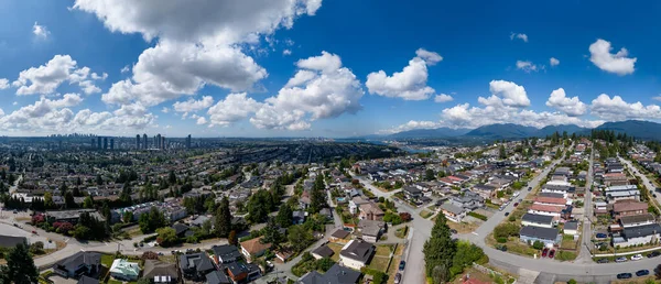 Vancouver yakınlarındaki Burnaby 'nin geniş açılı manzarası. Mavi gökyüzünün altındaki şehir ve dağ manzaraları..