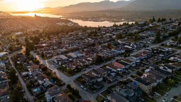 Burnaby, BC, Kanada 'nın huzurlu altın günbatımında geniş kentsel manzarası.