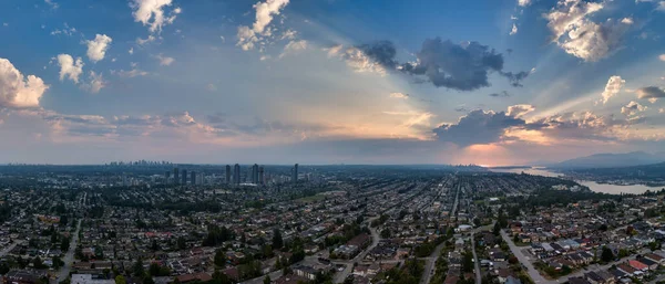 Burnaby, BC 'nin panoramik şehir manzarası, günbatımı gökyüzü ve dağ manzarası.