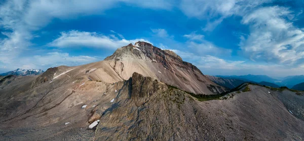 Göz kamaştırıcı bulutları ve açık mavi gökyüzü olan dağ sırtı BC, Kanada.