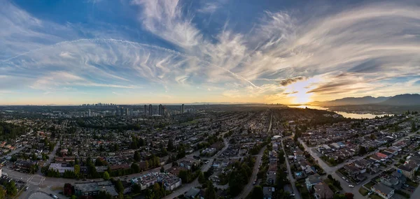 Burnaby, BC 'nin panoramik hava görüntüsü, günbatımı renkleri ve uzak şehir silueti.