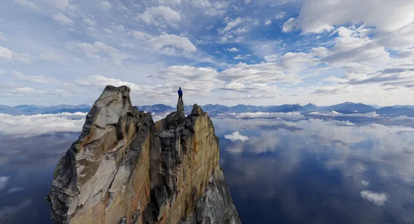 Yalnız bir figür engebeli bir uçurumun tepesinde, nefes kesen geniş bir arka planda duruyor..