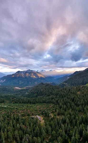 Çam ormanları ve engebeli tepeleri olan Alp Vadisi renkli bir günbatımı altında, Britanya Kolumbiyası, Kanada.