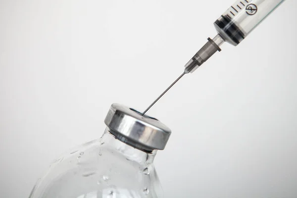 Beyaz arka planda enjeksiyonlu tıbbi şırınga
