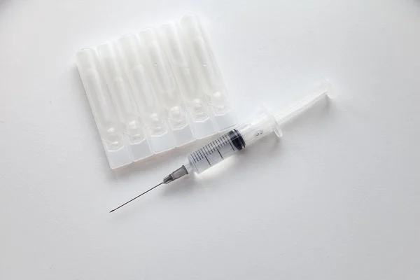 Beyaz arka planda enjeksiyonlu tıbbi şırınga