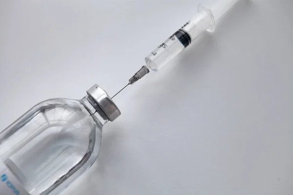 Beyaz arka planda enjeksiyonlu tıbbi şırınga
