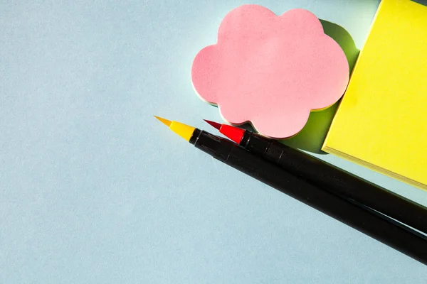 Mavi arkaplanda boş bir defter ve kalem