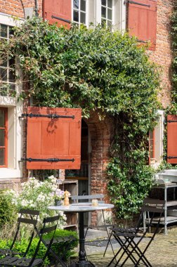 AMSTERDAM, NETHERLANDS - MAYIS 01, 2018: Oude Kerk kilisesinin eski kutsal odasındaki De Koffie schenkerij (Kahve ve Kek) Kafe 'de güzel masalar