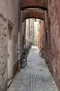 REGENSBURG, ALMANY - 11 Temmuz 2019: Eski şehrin dar sokaklarında park edilmiş bisikletler