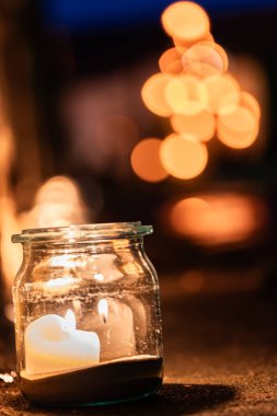 Camda mum ve arka planda romantik ışıklar. 