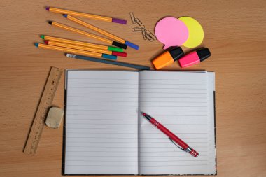 Masanın üzerinde Yazma Utensilleri olan Not Defteri