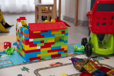 Yerde oyuncakları olan renkli oyun odası, yaratıcı karmaşa ve eğlenceli çocukluk atmosferi