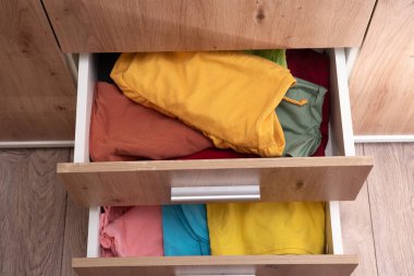 Katlanmış giysiler dolabın çekmecesinde.