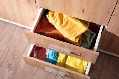 Katlanmış giysiler dolabın çekmecesinde.