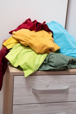 Elbise yığını dolabın açık çekmecesinde yatıyor. Etrafa saçılmış şeyler