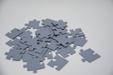 Beyaz arkaplanda duran bir yığın içindeki tek renkli bulmacalar