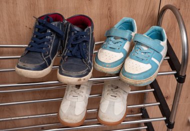 Çocukların odasının zeminine saçılmış bir çift kirli çocuk ayakkabısı. Dağınıklık ve temizlik