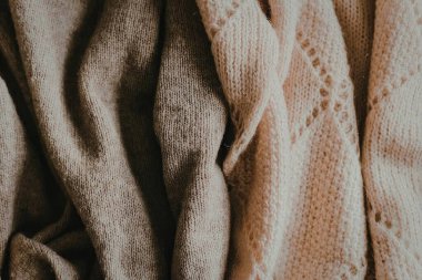 Tarafsız tonlarda örülmüş çeşitli kumaş dokularının yakın plan görüntüsü.