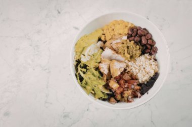 Izgara tavuk, karışık sebze, mısır, fasulye ve susam tohumlarıyla dolu besleyici bir kase..