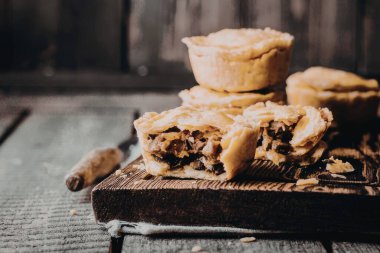 Ev yapımı etli turtaların olduğu ahşap bir tahta, dolguyu ortaya çıkarmak için bir kesik..