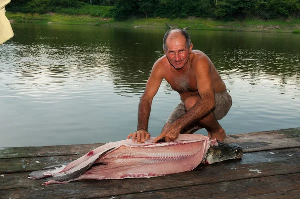 アマゾンの川近くの魚を持つ男 — ストック写真