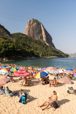 Sugar Loaf Dağı 'na güzel bir manzara ve insanlarla dolu plaj ve renkli şemsiyeler, Rio de Janeiro, Brezilya