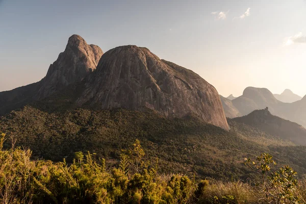 stock image Beautiful view to big rocky peak and other mountains on green rainforest during sunset time, Tres Picos State Park, Rio de Janeiro, Brazil