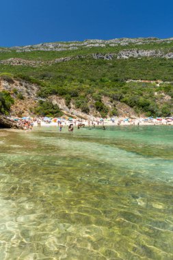 Güneşli bir günde Setubal, Lizbon, Portekiz yakınlarında turistlerle sahile güzel bir manzara.