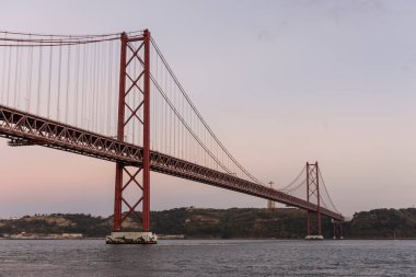 25 de Abril Köprüsü ve Tejo Nehri üzerindeki Cristo Rei 'ye gün batımında güzel bir manzara, Lizbon, Portekiz şehir merkezi