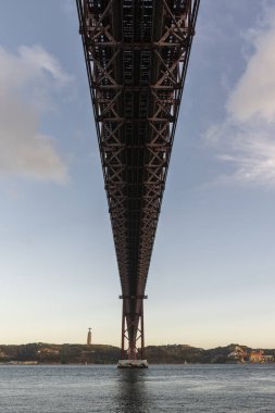 25 de Abril Köprüsü 'nün güzel manzarası Tejo Nehri ve Cristo Rei Heykeli üzerinde gün batımı saatinde, Lizbon, Portekiz şehir merkezi