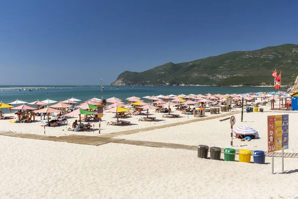 ポルトガル リスボン セトゥーバル近くの晴れた日に観光客や傘とビーチへの美しい景色 — ストック写真