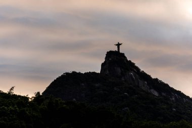 Günbatımı bulutlarıyla dağların tepesinde Kurtarıcı İsa 'nın güzel manzarası, Rio de Janeiro, Brezilya