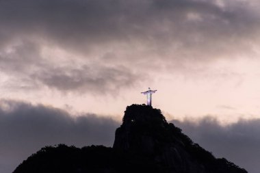 Günbatımı bulutlarıyla dağların tepesinde Kurtarıcı İsa 'nın güzel manzarası, Rio de Janeiro, Brezilya