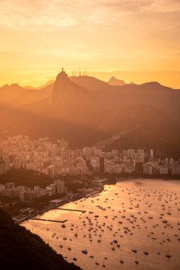 Şeker Somunu Dağı 'ndan Corcovado' ya ve Rio de Janeiro, Brezilya 'daki İsa Heykeli' ne güzel altın gün batımı manzarası