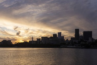 Brezilya 'nın Rio de Janeiro kentindeki binaların üzerindeki sarı bulutlara güzel gün batımı manzarası